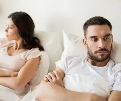 couple looking away from each other in bed