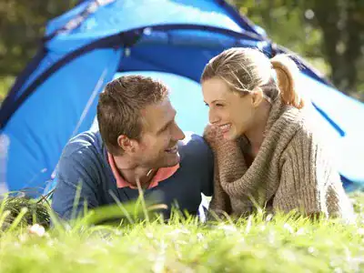 man and woman smiling outside tent